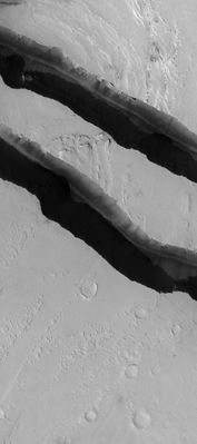 What's inside the Trough? (CTX Frame - Original NASA/MGS/MSSS b/w Frame)
Caption NASA originale:"This MGS-MOC image shows Channels carved by catastrophic Floods in the Tharsis Region of Mars. This area is located North/West of Jovis Tholus, and East of the large Martian Volcano Olympus Mons. The Terrain is presently mantled with fine Dust". 

Location near: 10,5° North Lat. and 203,4° West Long.
Image width: width: ~3 Km (~1,9 mi) 
Illumination from: lower left 
Season: Northern Autumn
Parole chiave: Mars from orbit - Troughs and Canyons