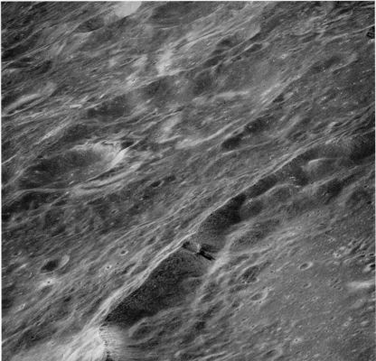 The Lobachevsky Anomaly in HR (context image from AS 16-121-19407)
An oblique view looking North-West at part of the wall of the crater Lobachevsky on the Lunar Far (or Dark) Side. It shows a small crater on Lobachevsky's wall with unusual streaks of dark material that appear to have originated from the lower rim of the structure and to have moved down toward the floor of Lobachevsky. This feature was first noticed by T. K. Mattingly, the Apollo 16 CMP, who described the darker streaks as probable lava flows (Mattingly, El-Baz, and Laidley, 1972). 
However, the streaks can also be explained by the downslope movement of dark fragmental debris excavated from Lobachevsky's wall by the small crater. Closer to the lower border of the photograph is a bright area extending across Lobachevsky's rim. This area and other sinuous light-colored markings in the upper half of the photograph are on the periphery of an enormous field of light-colored swirls in this part of the Far-Side (El-Baz, 1972a). 
The origin of the swirls is not well understood.
Parole chiave: The Moon from orbit - Lobachevsky
