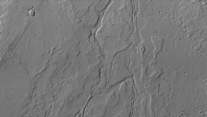Channels on Lava Flows in Tharsis (Original NASA/MGS/MSSS b/w Frame)
Caption NASA originale:"This MGS-MOC image shows ancient, Dust-covered Lava Flows and remains of leveed Lava Channels located on a Plain North/West of Jovis Tholus. 
Jovis is a relatively small volcano in the Tharsis Region of Mars".  

Location near: 22,4° North Lat. and 122,0° West Long.
Image width: ~3 Km (~1,9 mi)  
Illumination from: lower left  
Season: Northern Winter
Parole chiave: Mars from orbit - Volcanic Features - Lava Flows and Channels