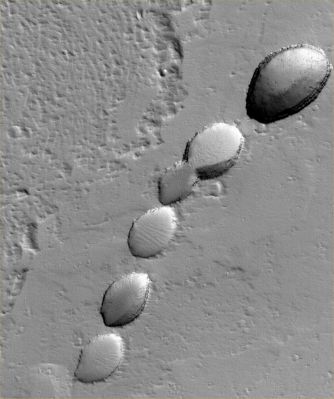 Collapse Pit-Chain in Tharsis Region (Original NASA/MGS/MSSS b/w Frame)
Caption NASA originale:"This MGS-MOC image shows a chain of collapse pits on a dust-mantled, lava-covered plain North-East of Ascraeus Mons (one of the giant volcanoes located in the Tharsis Region of Mars). 
Pit chains are associated with collapse which may be driven by several processes including, but not limited to, crustal extension owing to tectonic processes and the collapse of the roof of a lava tube".

Location near: 14,8° North Lat. and 99,1° West Long.
Image width: ~3 Km (~1,9 mi)  
Illumination from: lower left  
Season: Northern Winter
Parole chiave: Mars from orbit - Volcanic Features - Pit Chain