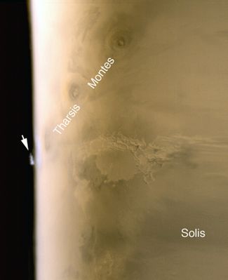 An isolated "Water Ice Cloud" over Tharsis or a volcanic "Plume"? (Saturated Natural Colors; credits: NASA/JPL/MSSS)
Original caption:"This composite of red and blue MGS-MOC daily global images acquired on 6 July 2005 shows an isolated water ice cloud extending more than 30 Km (more than 18 miles) above the Martian surface. Clouds such as this are common in late Spring over the terrain located South-West of the Arsia Mons volcano. Arsia Mons is the dark, oval feature near the limb, just to the left of the "T" (in the "Tharsis Montes" label). 
The dark, nearly circular feature above the "S" (in "Tharsis") is the Pavonis Mons Volcano and the other dark circular feature, above and to the right of "S" in "Montes," is Ascraeus Mons. 
Illumination is from the left/lower left. 
Season: Northern Autumn/Southern Spring".

Nota: purtroppo non ci sono vulcanologi nel Gruppo Lunar Explorer, ma la sensazione (nulla di più) che la "isolata nuvola di ghiaccio d'acqua", come la chiama la NASA sia, in realtà, il residuo di un evento vulcanico, è molto intensa (confrontate la sua forma con qualcuna delle "volcanic plumes" di Io...).
Parole chiave: Mars from orbit - Tharsis Region