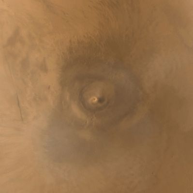 Arsia Mons Volcano and "spiral clouds" (Natural Colors; credits: NASA/JPL/MSSS)
Caption NASA originale:"One of the benefits of the MGS-MOC Extended Mission is the opportunity to observe how the planet's weather changes during a second full martian year. This picture of Arsia Mons was taken on June 19, 2001; Southern Spring equinox occurred the same day. Arsia Mons is a volcano nearly large enough to cover the state of New Mexico. On this particular day (the first day of Spring), the MOC wide angle cameras documented an unusual spiral-shaped cloud within the 110 Km diameter caldera - such as the summit crater - of the giant volcano. Because the cloud is bright both in the red and blue images acquired by the wide angle cameras, it probably consisted mostly of fine dust grains. The cloud's spin may have been induced by winds off the inner slopes of the volcano's caldera walls resulting from the temperature differences between the walls and the caldera floor, or by a vortex as winds blew up and over the caldera. Similar spiral clouds were seen inside the caldera for several days; we don't know if this was a single cloud that persisted throughout that time or one that regenerated each afternoon".
Parole chiave: Mars from orbit