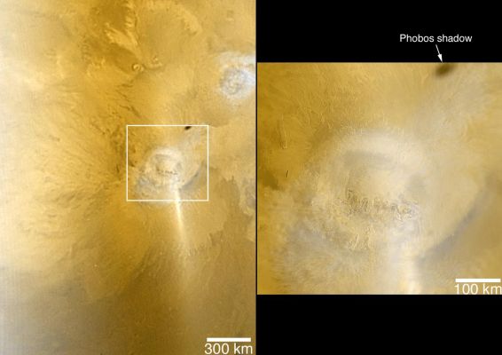 Arsia Mons with Water-Ice Clouds and the shadow of Phobos (credits NASA/JPL/MSSS)
Caption originale:"This pair of MGS-MOC color images shows early Autumn Clouds over the Arsia Mons Volcano, plus the shadow of the innermost of the Martain Moon Phobos. The picture on the left is taken from the MOC daily global map acquired at 7,5 km (~4,7 mi) per pixel on 28 January 2006, about a week after the start of Southern Autumn. 
The picture on the right was taken at the same time, but at a higher resolution of 489 mt (~1604 ft) per pixel. 
Both pictures are composites of MOC red and blue wide angle images, and both are oriented such that North is up and East is to the right. Arsia Mons and the other large Tharsis volcanoes commonly develop afternoon orographic (i.e., topographically-controlled) water ice clouds at this time of year. The equatorial Tharsis volcano, Pavonis Mons, is also under a deck of Water-Ice Clouds; it is located toward the upper right corner of the left, lower-resolution image. 
Sunlight glints off the dusty Surface and the Clouds and Aerosols in the Atmosphere, producing the bright diagonal Streak located just South/East (lower right) of Arsia Mons. A Water-Ice Haze is seen on the left side of the lower-resolution image. The dark oval to the North-East of Arsia Mons, as noted above, is the shadow of Phobos".
Parole chiave: Mars from orbit - Arsia Mons