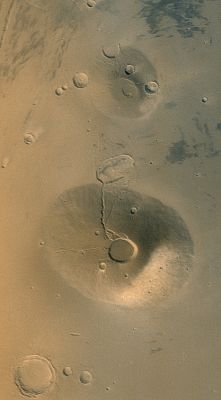 Ceraunius and Uranius (Over-Saturated Natural Colors; credits: NASA/MGS/MSSS)
Caption NASA originale:"Acquired in March 2002, this Mars Global Surveyor (MGS) Mars Orbiter Camera (MOC) wide angle view shows the martian volcanoes, Ceraunius Tholus (lower) and Uranius Tholus (upper). The presence of impact craters on these volcanoes, particularly on Uranius Tholus; indicates that they are quite ancient and are not active today. The light-toned area on the southeastern face (toward lower right) of Ceraunius Tholus is a remnant of a once more extensive deposit of dust from the global dust storm events that occurred in 2001. The crater at the summit of Ceraunius Tholus is about 25 Km (15,5 mi) across. Sunlight illuminates the scene from the lower left".
Parole chiave: Mars from orbit - Volcanoes - Ceraunius and Uranius Tholus