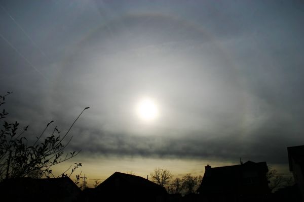 A Sun "Halo" in Tennessee
Dal "NASA - Picture of the Day" del 9 Marzo 2005:"Sometimes it looks like the Sun is being viewed through a large lens. In the above case there are actually millions of lenses: ice crystals. As water freezes in the upper atmosphere, small, flat, six-sided, ice crystals might be formed. As these crystals flutter down, much time is spent with their faces flat, parallel to the ground. An observer may pass through the same plane as many of the falling ice crystals near sunrise or sunset. During this alignment, each crystal can act like a miniature lens, refracting sunlight into our view. Dramatically visible behind neighborhood houses and trees and above the cloud deck is the 22° halo created by sunlight reflecting off of atmospheric ice crystals".
L'alone è spiegato in modo preciso ed accurato, ma esso non è l'unico fenomeno visibile in questa foto: alla Vostra Sx si vedono - e bene! - 2 scie chimiche. E quelle come le spieghiamo? Vapori e cristalli?!?
Parole chiave: The Sun