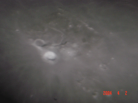 Aristarchus: the TLPs "Hottest Spot" (2)
Ecco come appare Aristarco in una (secondo noi eccellente, a dispetto dell'apparenza un pò sfuocata) ripresa da Terra.

Original caption:"Photograph shown here was taken using a 12.5 F 5 Newtonian reflector, with 12.5mm eyepiece and 2x Barlow. Using digital still camera DSC-P71 mounted for eyepiece projection. The photograph was taken on April 3. 2004 at 1:20 U.T.".
Parole chiave: The Moon from Earth - Amatorial Pictures