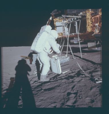 AS 12-46-6785 - Lunar Worker
Caption NASA originale:"116:34:14 MT - Alan Bean has placed the RTG package on the ground. Note the cooling fins on the RTG. Note the pull rings on the edge closest to Alan. These pull rings are used to release "pip pins" with which some pieces of equipment are attached to the RTG pallet. The light-colored piece of gear that is attached to the part of the RTG pallet that is on top in this picture is the SIDE (Suprathermal Ion Detection Experiment). Note the deployment rail and pulleys extending out from the SEQ bay above the upper ends of the lanyards. The distinctive ring-shaped top of the fuel cask can be seen behind the left-hand SEQ bay door. The landing radar is under the SEQ Bay, directly beneath the partition separating the two ALSEP compartments. The shield that protects the radar from descent engine exhaust is farther to the right. Note the saddlebag on Alan's left hip and note, also, that Pete's shadow shows that he is wearing one too".
Parole chiave: Astronauts on the Moon - Bean