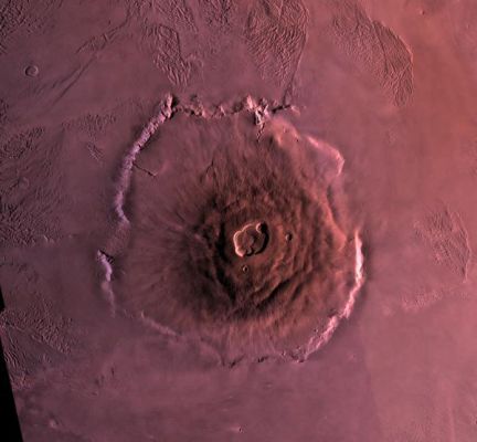 Olympus Mons (False Colors; credits: NASA)
Shown here is a digital mosaic of Olympus Mons, the largest known volcano in the Solar System. It is 27 Km high, over 600 Km at the base, and is surrounded by a well-defined scarp (scarp--->"scarpata") that is up to 6 Km high. Lava flows (lava flow--->"colata lavica") drape over the scarp in places. Much of the plains surrounding the volcano are covered by the ridged (to ridge--->verb.:"increspare"; ridge--->sost.:"crinali") and grooved (to groove--->verb.:"scanalare" o "incavare"; groove--->sost.:"solco" o "scanalatura") 'aureole' of Olympus Mons.
Parole chiave: Mars from orbit