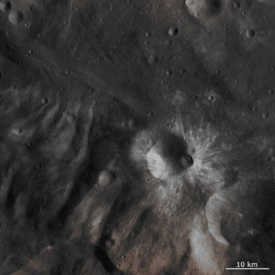 Tuccia Crater (Absolute Natural Colors; credits for the additional process. and color.: Drr Gianluigi Barca and Paolo C. Fienga - Lunexit Team)
This Dawn FC (framing camera) image is dominated by bright Rayed Craters of different sizes. The most prominent bright Rayed Crater is the approximately 8 Km diameter crater in roughly the center of the image. This Crater is named Tuccia and the Quadrangle in which it is located is named after it. Towards the bottom of the image its bright rays extend for over 10 Km but towards the top the Rays are much less extensive. Tuccia Crater has a smaller, fresher, younger Crater on its Rim which also seems to have bright rays emanating from it. It is clear that this smaller Crater is younger because it overprints the larger one and has a fresher, sharper Rim than Tuccia's. Slightly above these Craters is a much smaller, roughly 2 Km diameter, bright Rayed Crater. To the left of this Crater there is a patch of bright material that is associated with Craters that are only a few pixels in diameter. There is also a good example of the Hummocky (---> wavy/undulating) Terrain of Vesta's South Polar Region (visible at the bottom left of the frame). Tuccia Crater has been emplaced onto this Hummocky Terrain. 

This image is in Vesta's Tuccia Quadrangle and the center Latitude and Longitude of the image is 38,8° South and 200,2° East. NASA's Dawn Spacecraft obtained this image with its framing camera on October 17th 2011. This image was taken through the camera's clear filter. The distance to the Surface of Vesta is about 702 Km and the image has a resolution of about 70 meters per pixel. This image was acquired during the HAMO (High Altitude Mapping Orbit) phase of the mission.
Parole chiave: Asteroids - 4 Vesta