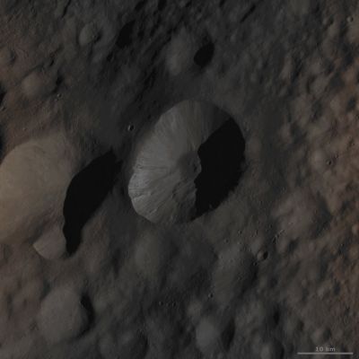 Licinia Crater (Absolute Natural Colors; credits for the additional process. and color.: Dr Paolo C. Fienga/Lunar Explorer Italia/Italian Planetary Foundation)
This NASA - Dawn Spacecraft Framing Camera (FC) image of 4-Vesta shows Licinia Crater, which is the large Impact Crater positioned in the center of the picture. Licinia Crater has a fresh, sharp Rim that is scalloped in shape; all around the Inner Walls of Licinia Crater there are many Streaks of Dark and Bright Dusty Material cascading towards the Crater's center. There are also many hummocky Slumps of Material around the Crater's Walls and Base. A large Mound of Material (most likely made of small Rocks and Dust) is well visible in the Crater's center, and the Mound itself is surrounded by more smooth and dark unidentified Material. The possibility that such (as of yet, we repeat, unidentified) smooth Material visible on 4-Vesta's Surface might be the so-called "Impact Melt" is currently under investigation. Licinia Crater is one of the freshest Impact Craters that can be seen in this image. 

This area visible here is located in the "Floronia Quadrangle" of 4-Vesta, in the Northern Hemisphere of the Giant Asteroid. The NASA - Dawn Spacecraft obtained this image with its Framing Camera (FC) on October 11, 2011. The image was taken through the Camera's Clear Filter and the distance of the Spacecraft from the Surface of 4-Vesta was, at the time that the picture was taken, of approx. 700 Km (such as a little less than 435 miles); the image has a resolution of about 63 meters (207 feet) per pixel. This picture of Licinia Crater was acquired during the HAMO (---> High-Altitude Mapping Orbit) phase of the mission. 

This frame (which is an Original NASA - Dawn Spacecraft b/w image published on the NASA - Planetary Photojournal with the ID n. PIA 16050) has been additionally processed and then colorized, according to an informed speculation carried out by Dr Paolo C. Fienga (LXTT-IPF), in Absolute Natural Colors (such as the colors that a human eye would actually perceive if someone were onboard the NASA - Dawn Spacecraft and then looked outside, towards the Giant Asteroid 4-Vesta), by using an original technique created - and, in time, dramatically improved - by the Lunar Explorer Italia Team. Different colors, as well as different shades of the same color, mean, among others, the existence of different Elements present on the Surface of 4-Vesta, each having a different Albedo (---> Reflectivity) and Chemical Composition.
Parole chiave: Asteroids - 4 Vesta