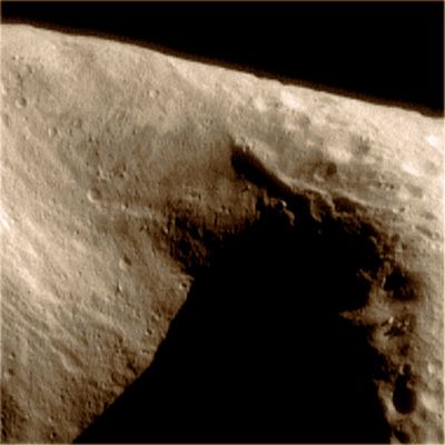 Looking at "The Saddle" (natural colors; credits: Lunexit)
This image of the interior of Eros' "Saddle Area", taken at a range of 204 Km (about 127 miles), displays a paucity of craters compared to the surface on the right hand side of the image. The Saddle displays many interesting structural features. Visible on the left wall are a series of closely spaced grooves that follow the terrain downslope. Opposite, on the upper right wall, trending towards the back of the saddle is a prominent ridge. Boulders are visible throughout this image. 
Features as small as 20 meters (65 feet) are discernable. 

(Image 0127521108)
Parole chiave: Asteroids - 433-Eros