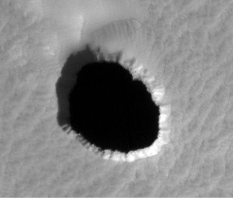Collapse Pit
Pit Craters exist in volcanic regions across Mars, and form when surface materials collapse into large underground cavities. Such Pits are generally bowl-shaped, filled with sediment, and are relatively shallow when compared with their diameters.
Recently, a small number of anomalous pit craters were identified with strikingly different visible and thermal characteristics such as: sheer cliff walls; deep interiors that can extend out-of-sight beneath the Surface and temperature fluctuations that behave unlike any known feature on Mars.
Parole chiave: Mars from orbit - Collapse Features - Pit