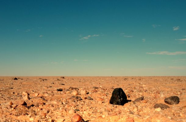 Almahata Sitta 15
Da "NASA - Picture of the Day", del giorno 28 Marzo 2009:"Small Asteroid 2008 TC3 fell to Earth at dawn on October 7, 2008, tracking through the skies over the Nubian Desert in Northern Sudan. That event was remarkable because it was the first time an asteroid was detected in space before crashing into planet Earth's Atmosphere. 
It was generally assumed the asteroid itself had completely disintegrated to dust. But, based on satellite and ground observations of the atmospheric impact event, Dr. Mauwia Shaddad of the University of Khartoum, aided by Dr. Peter Jenniskens of the SETI Institute and NASA Ames Research Center, led an expedition of students and staff to the area, combing the desert for surviving fragments. 
On December 6, 2008, 2 hours after their search began, the first meteorite was found. The team ultimately collected some 280 small meteorites, now called Almahata Sitta, with a total mass of about 5 kilograms -- the first material recovered from a known asteroid. In stark contrast to the lighter-colored stones, the black fragment in the picture is Almahata Sitta meteorite number 15. About 4 centimeters in diameter, it is seen as it came to rest on the desert floor".

Nota Lunexit: la fotografia, sebbene suggestiva, presenta - a nostro parere - delle notevoli incongruenze di texture e colore. In altre parole, sembra più un image-composite che un vero e proprio single still. 
Abbiamo quindi leggermente modificato la colorizzazione del frame, adattando il suolo al colore tipico della superficie del Deserto Sudanese (la "fotografia" originale sembra essere parecchio sovrasaturata) ed il colore blu del cielo è stato leggermente abbassato di tonalità ed intensificato (così ricreando - in visione - le condizioni atmosferiche tipiche dei cieli che sovrastano regioni desertiche in cui l'Atmosfera è estremamente secca e l'Opacità - Atmosferica - bassissima o nulla).
Parole chiave: Earth Surface