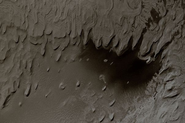Layers in Schiaparelli Crater (Natural Colors; credits: Lunexit)
Da "NASA - Picture of the Day", del giorno 29 Novembre 2009:"Is this a picture of Mars or Earth? 
Oddly enough, it is a picture of Mars. What may appear to some as a terrestrial coastline is in fact a formation of ancient layered hills and wind-blown sand on Mars. 
The above-pictured region spans about 3 Km in Schiaparelli Crater. What created the layers of sediment is still a topic of research. Viable hypotheses include ancient epochs of deposit either from running water or wind-blown sand. Winds and sandstorms have smoothed and eroded the structures more recently. 
The "water" that appears near the bottom is actually dark colored sand. The image was taken with the Mars Global Surveyor Spacecraft that operated around Mars from 1996-2006 and returned over 200.000 images".
Parole chiave: Mars from orbit - Craters - Schiaparelli Crater