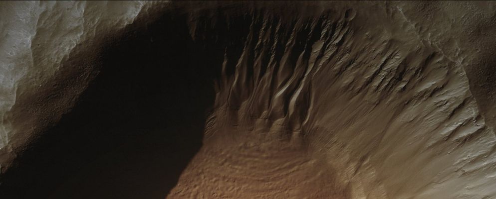 Unnamed Crater with Gullies (Absolute Natural Colors; credits for the additional process. and color.: Dr Paolo C. Fienga - Lunar Explorer Italia)
Caption NASA originale:"This MGS-MOC image shows Gullies and cracked and stressed Gully-Apron Deposits in a South Mid-Latitude Unnamed Crater. Gullies can also be seen in the deep shadow on the North Wall of the Crater. These Gullies might have formed by the erosive action of liquid water, sometime in the not-too-distant Martian Past". 

Location near: 36,7° South; 206,2° West
Image width: ~3 Km (~1,9 mi) 
Illumination from: upper left 
Season: Southern Autumn

Nota: attenzione a quello che la NASA ha scritto in sede di commento: adesso il passato al quale fare riferimento per pensare ad acqua che scorre "allo stato liquido" su Marte non è più remoto (un miliardo di anni o giù di lì); adesso questo passato è "...not too distant..." e cioè "passato prossimo". RicordateVi, in futuro, di quello che stiamo scrivendo da mesi: un frame dopo l'altro ed una parola dopo l'altra, la NASA si sta (lentamente ma) costantemente ridefinendo in chiave possibilista molte delle proprie posizioni (da anni più che consolidate) su molti aspetti/enigmi del Pianeta Rosso.
A quando l'ammissione di una "forma vitale" attuale, magari sotterranea?!?... 
Parole chiave: Mars from orbit - Craters - Unnamed Crater with Gullies