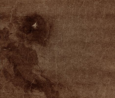 Possible Remnants of a Meteoroid in Lakshmi Region (possible Natural Colors; credits: Dr Paolo C. Fienga - Lunexit Team)
This full resolution mosaiced image covers an area of approx. 100 by 120 Km (such as about 62 by 74 miles) and is located in the Lakshmi Region of Venus, at 47° North Latitude and 334° East Longitude. 

Due to the dense Venusian Atmosphere, Primary Impact Craters of less than a 3 Km (a little less than 2 miles) diameter are nonexistent. 
The dark circular region and associated central bright feature in this image are thought to be the remnants of a Meteoroid smaller than the size necessary to create an Impact Crater, and entering the Atmosphere at low velocity (approx. 350 meters/second.) 
The central bright feature appears to be a cluster of small secondary impacts, ejecta and debris from the original meteor that broke up in the Atmosphere. 

Even though most of the meteorite did not hit the Surface, the Atmospheric Shock wave could be great enough to modify the surrounding region. One explanation for this radar dark circular formation, called "Dark Margins", could be that the shock wave was energetic enough to pulverize the Surface (smooth surfaces generally appear radar dark). 
Another explanation is that the Surface could be blanketed by a fine material that was formed by the original meteor's breakup through the Atmosphere. 

More than half of the Impact Craters on Venus have associated Dark Margins, and most of these are prominently located left of center of the rater. This is another effect which could be caused by the extremely dense Atmosphere of Venus. 
Parole chiave: Venus from orbit - Lakshmi Planum Regio