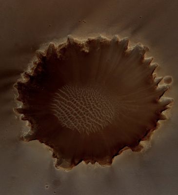 Victoria Crater (Natural Colors; credits: Lunexit)
This image of Victoria Crater in the Meridiani Planum Region of Mars was taken by the High Resolution Imaging Science Experiment (HiRISE) camera on NASA's Mars Reconnaissance Orbiter at more of a sideways angle than earlier orbital images of this feature. 
The camera pointing was 22° East of straight down, yielding a view comparable to looking at the landscape out an airplane window. East is at the top. The most interesting exposures of geological strata are in the steep walls of the Crater, difficult to see from straight overhead. 
Especially prominent in this oblique view is a bright band near the top of the Crater wall. 

Earlier HiRISE images of Victoria Crater supported the exploration of this Crater by NASA's Opportunity Rover and contributed to joint scientific studies. Opportunity explored the Rim and interior of this 800-meter-wide (about 0,5-mile-wide) Crater from September 2006 through August 2008. 
The Rover's on-site investigations indicated that the bright band near the top of the Crater wall was formed by diagenesis (chemical and physical changes in sediments after deposition). The bright band separates bedrock from the material displaced by the impact that dug the Crater. 

This view is a cutout from a HiRISE exposure taken on July 18, 2009. Some of Opportunity's Tracks are still visible to the North of the Crater (left side of this cutout). 
Full-frame images from this HiRISE observation, catalogued as ESP_013954_1780, are at http://hirise.lpl.arizona.edu/ESP_013954_1780. 
The full-frame image is centered at 2,1° South Latitude and 354,5° East Longitude. It was taken at 2:31 p.m. Local Mars Time. The scene is illuminated from the West with the Sun about 49° above the Local Horizon (therefore the S.I.A. was about 41°).
Parole chiave: Mars from orbit - Craters - Victoria Crater