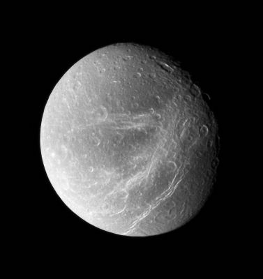 The "spiderweb like" streaks on Dione
Caption NASA:"Bright, wispy fractures streak across Dione's trailing side. Following the Voyager flybys of the early 80s, scientists considered the possibility that the streaks were bright material extruded by cryovolcanism. A quarter-century later, Cassini's close passes and sharp vision showed these features to be a system of braided canyons with bright walls. 
North on Dione is up. 

The image was taken in visible light with the Cassini spacecraft wide-angle camera on Sept. 30, 2007. The view was acquired at a distance of approx. 45.000 Km (such as about 28.000 miles) from Dione and at a Sun-Dione-spacecraft, or phase, angle of 36°. 
Image scale is roughly 3 Km (about 2 miles) per pixel".
Parole chiave: Saturn's Moons - Dione