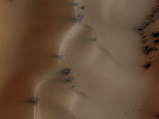 Dunes in Richardson Crater (EDM - Natural Colors; credits for the additional process. and color.: Dr Paolo C. Fienga - Lunexit Team)
This observation from NASA's Mars Reconnaissance Orbiter (MRO) is a view of the Sand Dunefield in Richardson Crater, still partually covered with seasonal frost.

This EDM is a close-up view of defrosting patterns on the Dunes. The frost is a combination of frozen CO2 and some water ice that covers the Dunes in the Winter and Spring. As the seasonal frost sublimes away, odd features such as spots, fans, and streaks form.
Small dark streaks on the dune slip-face slopes may be where recent avalanches of sand, or perhaps wind, has moved the dark sand underlying the frost, or where frost has been removed to expose the sand. Alternatively, the dark streaks may be patches of coarse-grained ice that are clear enough so that the dark material below the ice is visible. 
The slip-faces indicate the general direction of sand transport.

It has been hypothesized that the Dark Spots and Fans may be "geysers" or "cold gas jets" that form when sublimation processes trap gas at the bottom of the ice. The gas is released through cracks in the ice, entraining dust from below the ice and scattering it onto the Surface to form the Dark Spots and Fans.
Parole chiave: Mars from orbit - Craters - Richardson Crater