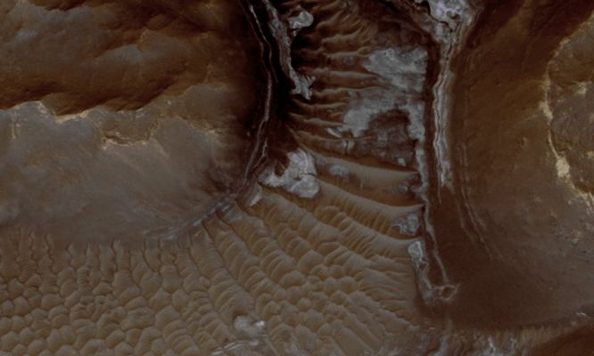 Light-Toned Deposits in Noctis Labyrinthus (EDM - Natural Colors; credits: Lunexit)
CRISM observations of this Region of the Noctis Labyrinthus formation have shown indications of Iron-bearing Sulfates and Phyllosilicate (such as "clay" ----> argilla) minerals.
HiRISE observations have revealed exposed layers which are possibly the sources of the signatures seen by CRISM. 
In this image, the layering can be seen on the right side of the image. 
On the lower left, instead, a large Dunefield which covers other beds can also be seen.
Parole chiave: Mars from orbit - Noctis Labyrinthus Region