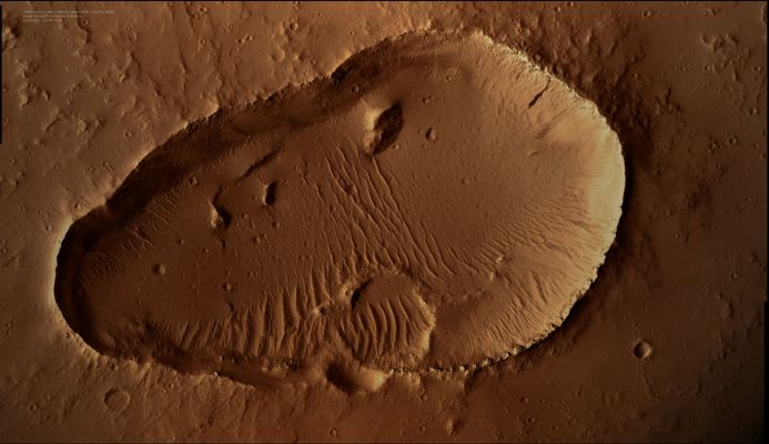 Small Shield Volcano with "Summit Caldera" (Saturated and Enhanced Natural Colors; credits: Dr M. Faccin - Lunexit Team)
Although there are a few truly giant Shield Volcanoes on Mars, there are also many smaller ones. 
There's a strong interest in imaging the Volcanic Vent Regions of Mars, in order to understand not only the Volcanic Processes themselves, but also to search for any signs of recent activity.
In fact, it has been suggested that active volcanism is one possible explanation for the Methane gas that has been detected in the Atmosphere of Mars. 

This HiRISE image shows that the Summit Caldera of a small Shield Volcano is mantled by Dust and covered by tiny Impact Craters. And it is just this last element (such as the existence of Impact Craters all over the Caldera) the one that allows us to believe that there are basically no chances that the imaged Volcano was active recently enough to affect the Atmosphere of Mars through the release of any gas whatsoever.
Parole chiave: Mars from orbit - Volcanic Features - Summit Caldera