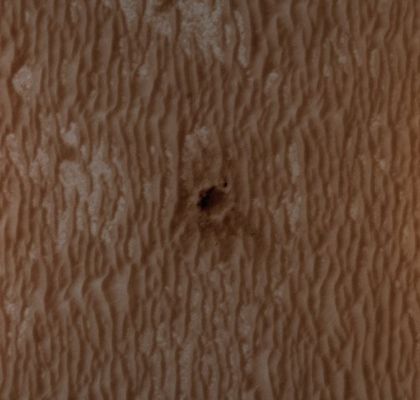 On the Edge of Concepci�n (EDM - Natural Colors; credits: Dr Paolo C. Fienga - Lunexit Team)
This EDM shows the Mars Exploration Rover Opportunity perched on the edge of Concepción Crater in Meridiani Planum, Mars.

Concepción Crater is a fresh, 10 meter-diameter crater with dark rays that clearly overprint the North trending Aeolian Ripples. 
The dark rays are produced by shadows cast by blocky ejecta and the presence of the rays and similar relationships with other fresh craters in Meridiani Planum indicate that this is likely the youngest crater visited by either Rover on Mars (estimated to have impacted thousands to tens of thousands of years ago).
Parole chiave: Mars from orbit - Meridiani Planum