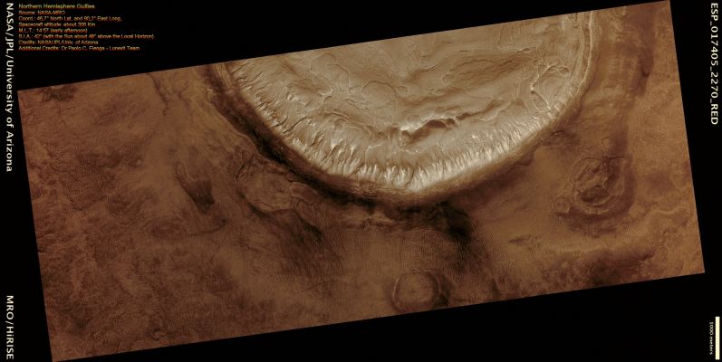 Northern Hemisphere Gullies on West-Facing Crater Slope (Natural Colors; credits for the additional process. and color.: Dr Paolo C. Fienga - Lunexit Team)
This image shows the Eastern (West-facing) side of an Unnamed Impact Crater in the Mid-Latitudes of the Northern Hemisphere. 

Like many Mid-Latitude Craters, this one has Gullies along its Walls that are composed of Alcoves, Channels and Debris Aprons. The origins of these Gullies have been the subject of much debate; they could have formed by flowing water, liquid Carbon Dioxide, or dry granular flows. The orientation of these Gullies is of interest because many Craters only contain Gullies on certain Walls, such as those that are Pole-facing. This could be due to changes in orbital conditions and differences in solar heating along specific Walls. 

Many of the other features observed in and around this Crater however are indicative of an ice-rich terrain, which may lend credence to the water formation hypothesis, at least for the Gullies visible here. The most notable of these features is the "Scalloped Terrain" in and around the Crater. 
This type of Terrain has been interpreted as a sign of surface caving, perhaps due to sublimation of underlying ice.

Another sign of ice is the presence of parallel lineations and pitted material on the Floor of the Crater, similar to what is referred to as concentric Crater Fill. Parallel linear cracks are also observed along the Crater Wall over the Gullies, which could be due to thermal contraction of ice-rich material.

All of these features taken together are evidence for ice-rich material having been deposited in this Region during different climatic conditions that has subsequently begun to melt and/or sublimate under current conditions. More recently, Aeolian Deposits have accumulated around the Crater as evidenced by the parallel ridges dominating the landscape. 
Dust Devil Streaks are also visible crossing the Aeolian Ridges.

Written by: Dan Berman
Parole chiave: Mars from orbit - Craters - Unnamed Crater with Gully-like Formations
