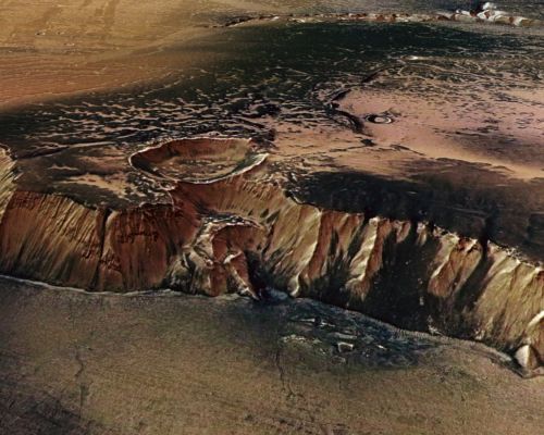 High Cliffs Surrounding Echus Chasma on Mars
What created this great cliff on Mars? Did giant waterfalls once plummet through its grooves? With a four-kilometer drop, this high cliff surrounding Echus Chasma, near an impressive impact crater, was carved by either water or lava. A leading hypothesis is that Echus Chasma, at 100-Km long and 10-Km wide, was once one of the largest water sources on Mars. If true, water once held in Echus Chasma likely ran over the Martian Surface to carve the impressive Kasei Valles, which extends over 3000 Km to the North. Even if initially carved by water, lava appears to have later flowed in the valley, leaving an extraordinarily smooth floor. Echus Chasma lies north of tremendous Valles Marineris, the largest canyon in the Solar System. The above image was taken by the robotic Mars Express spacecraft currently orbiting Mars.

Nota Lunexit: checchè ne dica la NASA, questo frame NON E' una fotografia.
Parole chiave: Artistic Visions