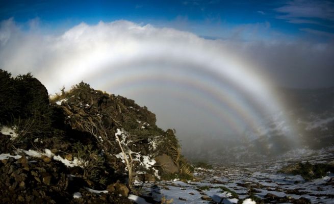 Glory never fades...
If you tried to enter this hall of fog, you would find it dissipates around you. The hall is actually an the mountain from which this picture was taken. 
Known as "The Glory", the phenomenon is frequently seen from airplanes. The ring's center is not visible, but if it were, the shadow of the observer would appear. This shadow would likely change as clouds passed, creating a faux moving giant known as the Brocken Spectre. 

Pictured above, several concentric rings of the glory appear to create a hall for this mountain king. The cause of The Glory has only been understood recently and is relatively complex. Briefly, small droplets of water reflect, refract, and diffract Sunlight backwards towards the Sun. The phenomenon has a counterpart in astronomy, where looking out from planet Earth in the direction opposite the Sun yields a bright spot called "The Gegenschein".
Parole chiave: Artistic Pictures