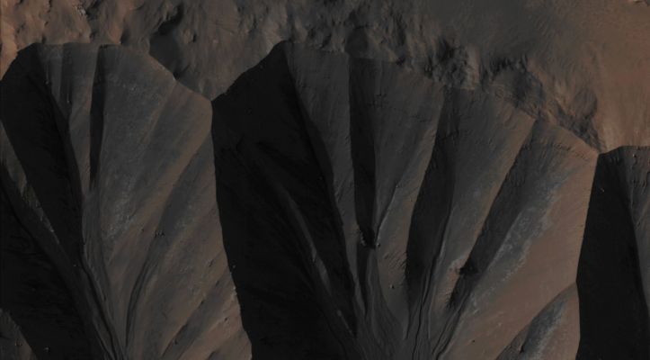 Gullies in Gasa Crater (Absolute Natural Colors; credits for the additional process. and color.: Dr Paolo C. Fienga/Lunar Explorer Italia/Italian Planetary Foundation)
The so-called "Gully Landforms" - just like the ones shown here, in this NASA - Mars Reconnaissance Orbiter image - can often be found in the Inner Rims (or even below, along the Inner Slopes) of many Impact Craters that are located at the Martian Mid-Latitudes. Some changes in these Gully Landforms were first seen in frames taken by the NASA - Mars Global Surveyor - Mars Orbiter Camera (MGS-MOC) in the AD 2006, and studying such activity has been a high priority for HiRISE ever since (and, in fact, many examples of New Deposits located inside Gully Landforms are now well known). 
This frame shows a New Deposit inside some Gully Landforms located on the Inner Rim of Gasa Crater; a very (relatively speaking) "fresh" approx. 7-Km diameter Impact Crater that is found in the Southern Mid-Latitudes of the Red Planet (to be precise, at 35,72° South Latitude and 129.45° East Longitude). Said New Deposit appears of a distinctive gray color, with some patches of white Material too, in this Absolute Natural Color version of the NASA - Mars Reconnaissance Orbiter image n. ESP_020661_1440. The picture was acquired during the Southern Spring of Mars, but the Flow that formed the Deposit occurred in the preceding Winter. 
As a matter of fact, the current Gully Activities appear to be concentrated in periods going from the late Winter to the early Spring of Mars, and this circumstance may be a consequence of the Sublimation of the Seasonal Carbon Dioxide (CO2) Frost (which, by the way, is well visible in several Gully "Alcoves" during Wintertime). 

Mars Local Time: 15:49 (Middle Afternoon)
Coord. (centered): 35,729° North Lat. and 129,386° East Long.
Spacecraft altitude: 258,2 Km (such as about 160,3 miles) 
Original image scale range: 25,8 cm/pixel (with 1 x 1 binning) so objects ~ 78 cm across are resolved
Map projected scale: 25 cm/pixel
Map projection: EQUIRECTANGULAR
Emission Angle: 11,0° 
Sun-Mars-Spacecraft (or Phase) Angle: 47,6°
Solar Incidence Angle: 58° (meaning that the Sun was about 32° above the Local Horizon at the time the picture was taken)
Solar Longitude: 203,7° (Northern Fall - Southern Spring)
Credits: NASA/JPL/University of Arizona
Additional process. and coloring: Lunar Explorer Italia

This picture (which is an Original Mars Reconnaissance Orbiter EDM enhanced color frame, identified by the serial n. ESP_020661_1440) has been additionally processed and then re-colorized in Absolute Natural Colors (such as the colors that a human eye would actually perceive if someone were onboard the NASA - Mars Reconnaissance Orbiter and then looked down, towards the Surface of Mars), by using an original technique created - and, in time, dramatically improved - by the Lunar Explorer Italia Team.
Parole chiave: Mars from orbit - Craters - Gasa Crater