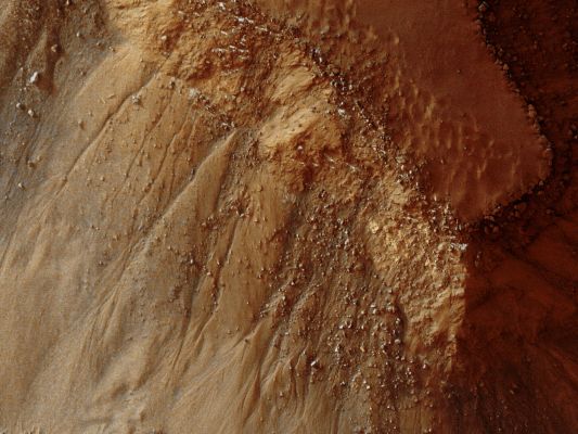 Gullies in Gorgonum Chaos (Natural Colors; credits for the additional process. and color.: Dr Paolo C. Fienga - Lunexit Team)
This observation from NASA's Mars Reconnaissance Orbiter (MRO) shows part of Gorgonum Chaos, a large cluster of Chaotic Terrain found in the Southern Hemisphere.

Many Regions of Chaotic Terrain are found at the head of large Outflow Channels that were scoured by ancient floods. Gorgonum Chaos is one Region that is NOT associated with an Outflow Channel.
Chaotic Terrain can form when Subsurface Volatiles (such as water) are catastrophically released and the overlying surface collapses. It is not known whether isolated Chaotic Terrain -- such as that shown in this image -- formed in the same way that the ones near the Outflow Channels did. However, some wind-erosion activity might have played a role in their formation.

Gorgonum Chaos is an especially interesting area because Gullies thought to have been eroded by liquid water are located on its Mesas. The Gullies have a wide range of orientations and many appear to emanate from a distinct layer in the Mesas. It is not known why Gullies form on one slope rather than another, but the "Insolation" (sucgh as the amount of sunlight received), availability of water, and regional slope are possible contributing factors.
Parole chiave: Mars from orbit - Gullies - Gorgonum Chaos Region