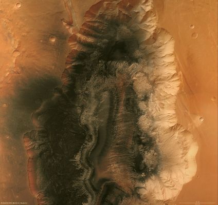 Hebes Chasma (Natural Colors + MULTISPECTRUM; credits: ESA and Lunexit)
The Region is an "Enclosed Trough" situated in Valles Marineris, the Grand Canyon of Mars, where water is believed to have flowed. The High Resolution Stereo Camera (HRSC) on ESA’s Mars Express studied the area providing new pictorial clues to its history. 
Hebes Chasma is located at approx. 1° South Lat. and 282° East Long. Image data was obtained on 16 September 2005 with a ground resolution of approx. 15 mt/pixel. 

The Region is an enclosed, almost 8 Km-deep trough in the most northern part of Valles Marineris, the 3000-Km long “Grand Canyon of Mars”. 
The steep flanks of the trough show branched incisions and small veins of rock. Below the flanks, run-off and material from larger landslides is also visible. 
A flat-topped mountain is located in the centre of Hebes Chasma. 
It reaches 8000 mt above the graben floor and rises to almost the same height as the plains surrounding the trough. 
Parole chiave: Mars from orbit - Hebes Chasma