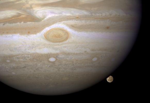 Hiding... (natural colors; credits: NASA)
NASA's Hubble Space Telescope has caught Jupiter's moon Ganymede playing a game of "peek-a-boo", In this crisp Hubble image, Ganymede is shown just before it ducks behind the giant planet.

Ganymede completes an orbit around Jupiter every 7 days. Because Ganymede's orbit is tilted nearly edge-on to Earth, it routinely can be seen passing in front of and disappearing behind its giant host, only to reemerge later.
Composed of rock and ice, Ganymede is the largest moon in our Solar System. It is even larger than the planet Mercury. 
But Ganymede looks like a dirty snowball next to Jupiter, the largest planet in our solar system. Jupiter is so big that only part of its Southern Hemisphere can be seen in this image.

Hubble's view is so sharp that astronomers can see features on Ganymede's surface, most notably the white impact crater, Tros, and its system of rays, bright streaks of material blasted from the crater. Tros and its ray system are roughly the width of Arizona.

The image also shows Jupiter's Great Red Spot, the large eye-shaped feature at upper left. A storm the size of two Earths, the Great Red Spot has been raging for more than 300 years. Hubble's sharp view of the gas giant planet also reveals the texture of the clouds in the Jovian Atmosphere as well as various other storms and vortices.

Astronomers use these images to study Jupiter's Upper Atmosphere. As Ganymede passes behind the giant planet, it reflects sunlight, which then passes through Jupiter's Atmosphere. Imprinted on that light is information about the gas giant's atmosphere, which yields clues about the properties of Jupiter's high-altitude haze above the cloud tops.

This color image was made from three images taken on April 9, 2007, with the Wide Field Planetary Camera 2 in red, green, and blue filters. The image shows Jupiter and Ganymede in close to natural colors.
Parole chiave: From Space Images - Hubble Space Telescope (HST) Images