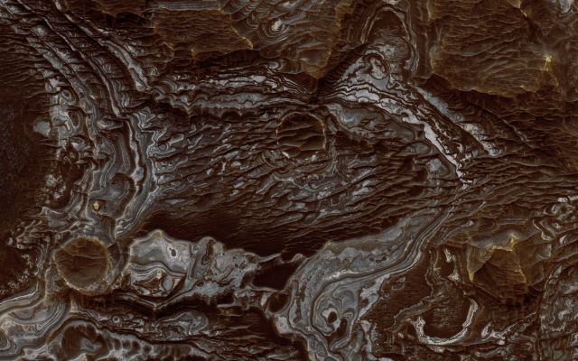 Bright Layered Deposits near Juventae Chasma (Natural Colors; credits: Dr Paolo C. Fienga - Lunexit Team)
This view shows color variations in bright Layered Deposits on a plateau near Juventae Chasma in the Valles Marineris egion of Mars. A brown mantle covers portions of the bright deposits. The view covers an area about of 1,2 Km (three-fourths of a mile) across.
The image comes from an observation made by the High Resolution Imaging Science Experiment (HiRISE) camera on NASA's Mars Reconnaissance Orbiter on May 2, 2007.
Researchers have found that these bright Layered Deposits contain Opaline Silica and Iron Sulfates, consistent with low-temperature, acidic aqueous alteration of basaltic materials. They conclude that aqueous activity affected this plateau after formation of the nearby canyons. Although the source of water and sediment remains uncertain, the strong correlation between fluvial landforms and bright Layered Deposits in this Region argues for sustained precipitation, surface runoff, and fluvial deposition occurring during Mars' Hesperian Era on the plateaus adjacent to Valles Marineris and along portions of the canyon walls. 

This image is one product from HiRISE observation PSP_003579_1755, centered at 4,7° South Lat. and 296,4 East Long.
Parole chiave: Mars from orbit - Layered Deposits
