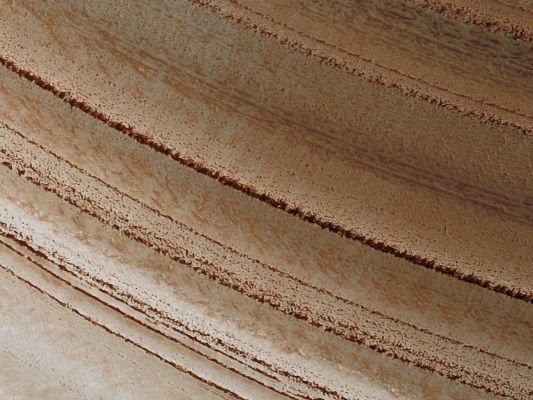 North Polar Layered Deposits (Natural Colors; credits for the additional process. and color.: Dr Paolo C. Fienga - Lunexit Team)
The Martian North Polar Layered Deposits (NPLD) are an ice sheet much like the Greenland ice sheet on the Earth. Just as with the ice sheet in Greenland this Martian ice sheet contains many layers that record variations in the Martian Climate. Sometimes icy layers can be ablated away during warm climates. Later the ice sheet can be buried by new ice layers and grow in size again. It's likely that many of these cycles have occurred over the ice sheet's history.

The High Resolution Imaging Science Experiment (HiRISE) camera on NASA's Mars Reconnaissance Orbiter recorded this image of NPLD on March 11, 2010. The target for this observation was a suggestion submitted by Greg Clements through the camera team's HiWish public-suggestion program. For more information about how to submit target suggestions, see http://uahirise.org/hiwish/.

Fluctuations in the thickness of the ice sheet are most pronounced at the edges of the sheet, where this HiRISE image was taken. The ice sheet ends here in a gentle scarp that slopes about 8° downhill from bottom to top in this image. The layering within the ice is exposed on this Sloping Surface. The thickness of the ice here is about 1 Km (approx. 3300 feet). Scientists are analyzing these layers to see what information they might hold regarding previous Martian Climates.

This image covers a swath of ground about 1 Km (approx. two-thirds of a mile) wide. 
It is a portion of HiRISE observation ESP_016973_2595, which is centered at 79,30° North Latitude and 351,46° East Longitude. 
The season on Mars is Northern-Hemisphere Spring.
Parole chiave: Mars from orbit - North Polar Features - NPLD