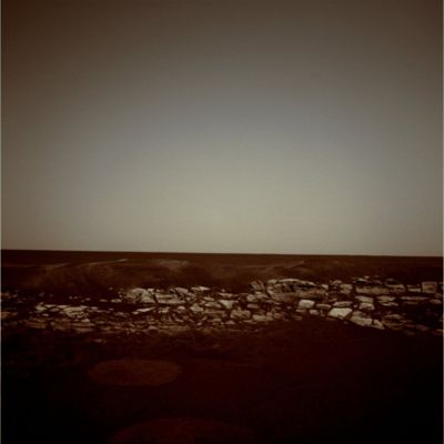 Eagle Crater Panorama (1) - Sol 5 (Natural Colors; credits: Lunar Explorer Italia)
Non meravigliateVi per il tipo di colorizzazione che abbiamo ottenuto: è genuino (nel senso che non abbiamo "toccato" i parametri standard della colorizzazione made by Lunexit).

Il punto è che le primissime immagine in arrivo da Meridiani Planum, quale che sia il processing di colorizzazione da noi utilizzato (MULTISPECTRUM; Natural Colors; possible True Colors etc.), confermano sempre queste caratteristiche cromatiche dell'ambiente: la superficie è color rosso acceso ed il cielo biancastro, con riflessi azzurri e rossi (verso l'orizzonte). 
La nostra opinione è che questo tipo di colore (comunque non surreale, anzi...) dipenda sia dal fatto che gli obbiettivi delle camere di Opportunity erano nuovi e pulitissimi, sia dal fatto che la calibrazione effettuata a Terra - ma sulla Scala dei Grigi - era ancora imperfetta.

Ci è difficile dire, comunque, se sia più "vero" questo color rosso scuro, con punte marroni, dei primi Soles, oppure l'arancio-giallo, con note ora verdastre ed ora marroni, degli ultimi.
Parole chiave: Martian Surface - Craters - Eagle Crater