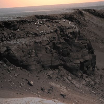 Cape St. Vincent (natural - but sligthly darkened - colors; MULTISPECTRUM processing; credits: Lunexit)
Caption NASA:"The cliff in this image from Opportunity's PanCam is informally named Cape St. Vincent. It is a promontory approx. 12 mt (39 feet) tall on the Northern Rim of Victoria Crater, near the farthest point along the Rover's traverse around the rim. Layers seen in Cape St. Vincent have proven to be among the best examples of meter scale cross-bedding observed on Mars to date. Cross-bedding is a geologic term for rock layers which are inclined relative to the horizontal and which are indicative of ancient sand dune deposits. In order to get a better look at these outcrops, Pancam Super-Resolution (SR) imaging techniques were utilized. 
SR is a type of imaging mode which acquires many pictures of the same target to reconstruct a digital image at a higher resolution than is native to the camera. 
These SR images have allowed scientists to discern that the rocks at Victoria Crater once represented a large Dunefield, not unlike the Sahara desert on Earth, and that this Dunefield migrated with an ancient wind flowing from the North to the South across the Region. Other Rover chemical and mineral measurements have shown that many of the ancient sand dunes studied in Meridiani Planum were modified by surface and subsurface liquid water long ago. 

This is a Mars Exploration Rover Opportunity PanCam image acquired on Sol 1167 (May 7, 2007), and was constructed from a mathematical combination of 16 different blue filter (480 nm) images".
Parole chiave: Victoria Crater - Cape St. Vincent