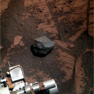 Interesting Rock-fragment  - Sol 1748 (True Colors; credits: Dr G. Barca)
L'osservazione di questo piccolo frammento di roccia dai riflessi bluastri costituisce un eccellente banco di prova per testare quello strumento di analisi scientifica (basata sull'osservazione in modalità remota) che abbiamo chiamato "Contestualizzazione".
Il panorama di riferimento lo conoscete: il MER Opportunity è stazionario, da qualche Sol, su un Pavimento Marziano Affiorante, ricoperto di berries. 
Osservazioni: il colore del Pavimento è arancio-marrone, con riflessi rossastri mentre il colore del nostro frammento è grigio/blu; la surface texture del Pavimento è (se non altro in apparenza) ruvida e grezza mentre quella del frammento di roccia è liscia; l'albedo del Pavimento è bassa, ma quella del frammento - specie sulla sua porzione (diciamo così) "frontale" e rivolta verso il Rover - appare medio/alta (si direbbe addirittura che il frammento di roccia abbia una Matrice, se non altro in parte, cristallina). 
Inoltre (dettaglio quanto meno curioso), i segni di deposito di polveri sottili sul frammento roccioso paiono decisamente leggeri ed appena accennati sulla sua porzione superiore e nettamente più marcati su quella laterale ed opposta all'angolo di osservazione.

Che cosa possiamo dedurre, a questo punto, sul frammento in questione? Fondamentalmente due cose: 

1) esso NON è un frammento di Pavimento Marziano (non è contestualizzabile nel contesto al quale accede); 
2) esso ha RECENTEMENTE (o forse addirittura RECENTISSIMAMENTE) trovato la sua attuale configurazione superficiale.

Conclusioni (interlocutorie): si dovrebbe trattare di un ejecta oppure è un frammento di un corpo non indigeno di questa zona di Meridiani (potrebbe anche essere un frammento di un meteorite).
Parole chiave: Martian Surface - Rock-fragment