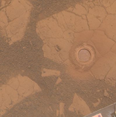 Gagarin Rock - Sol 405 (Approx. True Colors; credits for the additional process. and color.: NASA/JPL-Caltech/Cornell Univ./ASU)
Caption NASA:"NASA's Mars Exploration Rover Opportunity used its Rock Abrasion Tool on a rock informally named "Gagarin" during the 401st and 402nd Martian Days, or Soles, of the rover's work on Mars (such as March 10 and 11, 2005). 

This image shows the Circular Mark created where the tool exposed the interior of the rock Gagarin at a target called "Yuri". The circle is about 4,5 cm (1,8") in diameter. Gagarin is at the edge of a highly eroded, small crater that was informally named "Vostok" (after the Spacecraft that carried Cosmonaut Yuri Gagarin in the first human spaceflight, on April 12, 1961).

This image combines exposures taken through three different filters by Opportunity's PanCam (PanCam) on Sol 405 (March 14, 2005). The view is presented in Approximately True Color".
Parole chiave: Martian Surface - "RAT" Mark