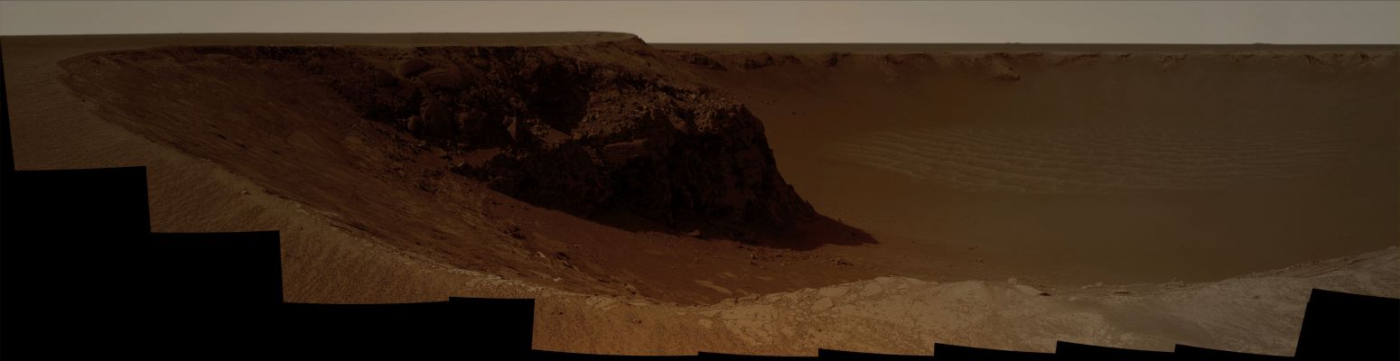 Victoria's Panorama (1) - Sol 970 (Natural Colors; credits: Dr G. Barca)
NASA's Mars Exploration Rover Opportunity captured this vista of "Victoria Crater" from the viewpoint of "Cape Verde", one of the promontories that are part of the scalloped rim of the Crater. Opportunity drove onto Cape Verde shortly after arriving at the rim of Victoria in September 2006. 

The view combines hundreds of exposures taken by the Rover's PanCam. The camera began taking the component images during Opportunity's 970th Martian day, or Sol, on Mars (such as Oct., 16, 2006). Work on the panorama continued through the Solar Conjunction Period, when Mars was nearly behind the Sun from Earth's perspective and communications were minimized. Acquisition of images for this panorama was completed on Opportunity's 991st Sol (such as Nov., 7, 2006). 

The top of Cape Verde is in the immediate foreground at the center of the image. To the left and right are two of the more gradually sloped bays that alternate with the cliff-faced capes or promontories around the Rim of the crater. 
"Duck Bay", where Opportunity first reached the rim, is to the right. 
Beyond Duck Bay counterclockwise around the Rim, the next promontory is "Cabo Frio", about 150 meters (500 feet) from the rover. On the left side of the panorama is "Cape St. Mary", the next promontory clockwise from Cape Verde and about 40 meters (130 feet) from the Rover. 
The vantage point atop Cape Verde offered a good view of the rock layers in the cliff face of Cape St. Mary, which is about 15 meters or 50 feet tall. 

By about two weeks after the PanCam finished collecting the images for this panorama, Opportunity had driven to Cape St. Mary and was photographing Cape Verde's rock layers. 

The far side of the Crater lies about 800 meters (half a mile) away, toward the South-East. 
Parole chiave: Martian Surface - Craters - Victoria Crater