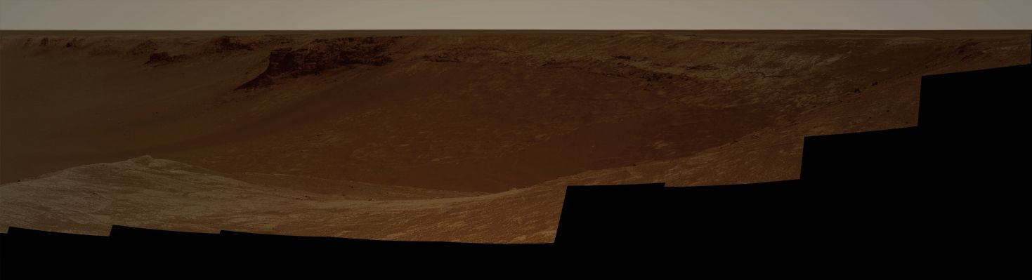 Victoria's Panorama (2) - Sol 970 (Natural Colors; credits: Dr G. Barca)
NASA's Mars Exploration Rover Opportunity captured this vista of "Victoria Crater" from the viewpoint of "Cape Verde", one of the promontories that are part of the scalloped rim of the Crater. Opportunity drove onto Cape Verde shortly after arriving at the rim of Victoria in September 2006. 

The view combines hundreds of exposures taken by the Rover's PanCam. The camera began taking the component images during Opportunity's 970th Martian day, or Sol, on Mars (such as Oct., 16, 2006). Work on the panorama continued through the Solar Conjunction Period, when Mars was nearly behind the Sun from Earth's perspective and communications were minimized. Acquisition of images for this panorama was completed on Opportunity's 991st Sol (such as Nov., 7, 2006). 

The top of Cape Verde is in the immediate foreground at the center of the image. To the left and right are two of the more gradually sloped bays that alternate with the cliff-faced capes or promontories around the Rim of the crater. 
"Duck Bay", where Opportunity first reached the rim, is to the right. 
Beyond Duck Bay counterclockwise around the Rim, the next promontory is "Cabo Frio", about 150 meters (500 feet) from the rover. On the left side of the panorama is "Cape St. Mary", the next promontory clockwise from Cape Verde and about 40 meters (130 feet) from the Rover. 
The vantage point atop Cape Verde offered a good view of the rock layers in the cliff face of Cape St. Mary, which is about 15 meters or 50 feet tall. 

By about two weeks after the PanCam finished collecting the images for this panorama, Opportunity had driven to Cape St. Mary and was photographing Cape Verde's rock layers. 

The far side of the Crater lies about 800 meters (half a mile) away, toward the South-East. 
Parole chiave: Martian Surface - Craters - Victoria Crater