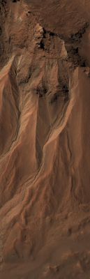 Gullies at the Edge of Hale Crater (Natural Colors; credits: NASA/JPL/Univ. of Arizona)
This image from the High Resolution Imaging Science Experiment (HiRISE) camera on NASA's Mars Reconnaissance Orbiter shows Gullies near the edge of Hale Crater on Southern Mars. The view covers an area about 1 Km (0,6 miles) across and was taken on Aug. 3, 2009. 
Martian Gullies carved into hill slopes and the walls of impact craters were discovered several years ago. Scientists are excited to study these features because, on Earth, they usually form through the action of liquid water -- long thought to be absent on the Martian Surface. Whether liquid water carves gullies under today's cold and dry conditions on Mars is a major question that planetary scientists are trying to answer. 

The Gullies pictured here are examples of what a typical Martian Gully looks like. You can see wide V-shaped channels running downhill (from top to bottom) where the material that carved the gully flowed. At the bottom of the channel this material empties out onto a fan-shaped mound. The fans from each gully overlap one other in complicated ways. At the tops of the channels, large amphitheater-shaped alcoves are carved in the rock. The material removed from these alcoves likely flowed downhill to the aprons through the Gullies. 
The terrain in this image is at 36,5° South Latitude and 322,7° East Longitude. 

Gullies at this site are especially interesting because scientists recently discovered actively changing examples at similar locations. Images separated by several years showed changes in the appearance of some of these Gullies. Today, planetary scientists are using the HiRISE camera to examine Gullies such as the one in this image for change that might provide a clue about whether liquid water occurs on the Surface of Mars. 

Full-frame images, catalogued as ESP_014153_1430, are at http://hirise.lpl.arizona.edu/ESP_014153_1430. 
The image was taken at 2:21 p.m. Local Mars Time, with the sun 54° above the horizon (S.I.A. = 36°). 
The season was Summer in the Southern Hemisphere of Mars.
Parole chiave: Mars from orbit - Craters - Hale Crater