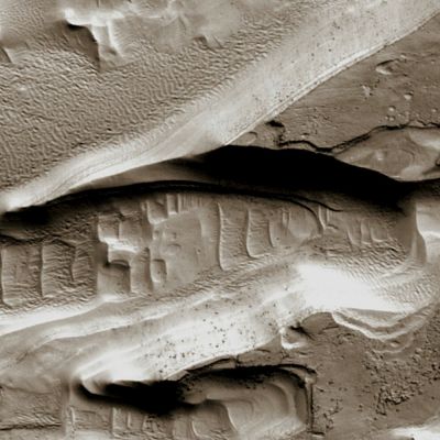 Eroding Layers in an Unnamed Southern Crater (EDM - Natural Colors; credits: Dr Paolo C. Fienga - Lunexit Team)
This EDM is approx. 250 meters wide. 

Boulders are visible on the Slopes of the Ridges along with thin Dark Layers including the Cap Layer, but they are absent on the Spurs, where the resistant cover has been eroded. 
This demonstrates that the Boulders come only from the Dark Layers, and are not embedded in the rest of the Deposit.
Parole chiave: Mars from orbit - Layers