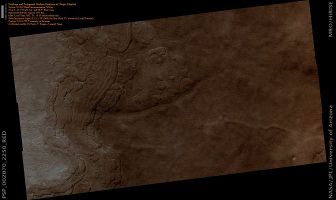 Polygons in Utopia Planitia (Absolute Natural Colors; credits for the additional process. and color.: Dr Paolo C. Fienga - Lunexit Team) 
This observation, in the Utopia Planitia, is marked by Depressions in the Mantle, several of which have coalesced together and now possess Scalloped edges and Layers. 

Scalloped pits, such as these, are typical features of the Mid-Latitude Mantle and are most commonly found at approx. 55° both North and South Latitude; in the Utopia Planitia, Scalloped Terrain is found between 45-50° North latitude where the Mantle is highly discontinuous. The presence of Scalloped Pits has led to hypotheses of the removal of Sub-Surface material, possibly interstitial ice, by Sublimation. Scalloped Depressions in the Utopia Planitia have also been interpreted to be "Thermokarst Lakes" created by melting of Permafrost (frozen ground) and collapse of the dry Surface Layer. 

Scalloped Pits typically have a steep Pole-facing Scarp and a gentler Equator-facing Slope. This is most likely due to differences in solar heating.
Parole chiave: Mars from orbit - Polygons - Utopia Planitia Region