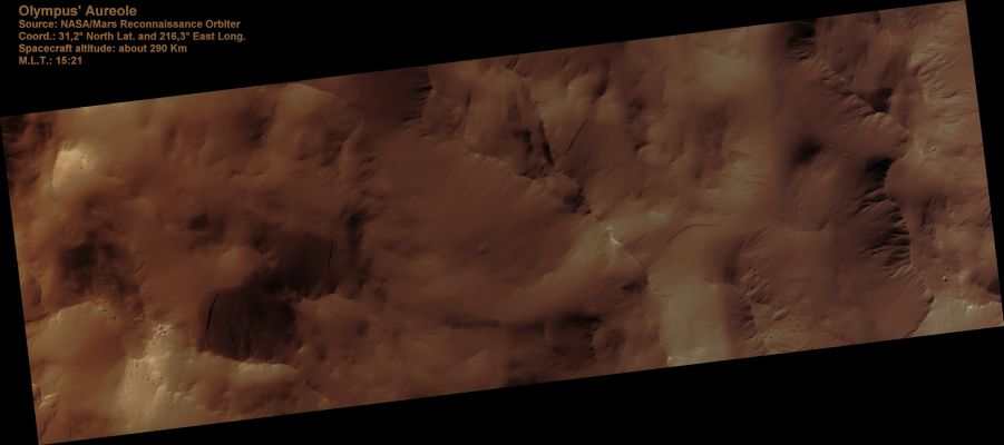 Olympus' Aureole (Absolute Natural Colors; credits for the additional process. and color.: Dr Paolo C. Fienga - Lunexit Team)
This image samples the rugged central portion of the mysterious "aureole" that extends to the West and North of Olympus Mons.

While many ideas for its formation have been advanced over the decades, these days it is generally thought to be a giant landslide deposit. The scene here fits that model with kilometer-scale (mile-sized) rocky hummocks and blocks strewn about. The blocks themselves are now covered with dust that is slumping off in small landslides or avalanches. These leave dark streaks on the sides of the blocks. 
Parole chiave: Mars from orbit - Volcanoes - Olympus Mons