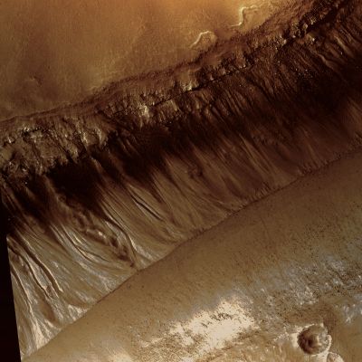 Mesas in Gorgonum Chaos (edm - possible True Colors; credits: Lunar Explorer Italia)
PSP_004071_1425 shows mesas that are part of Gorgonum Chaos, a region of chaotic terrain, which is a jumble of mounds and mesas grouped together. 
Chaotic terrain is most commonly found in Mars near the sources of the gigantic outflow channels. Gorgonum Chaos is one of the few exceptions.

Some of the troughs between the mesas appear to have V-shaped bottoms; there is no obvious flat floor in between. Others have dunes running down their centers probably indicating flat floors. It is possible that the mesas were once connected and that something caused fractures in the original mesa's surface that were then preferentially eroded.
Parole chiave: Mars from orbit - Gorgonum Chaos Region