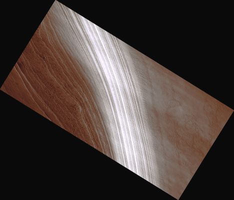 Polygons on South Polar Layered Deposits
This image shows an exposure of south polar layered deposits, thought to record recent global climate changes on Mars.
The layers were probably laid down over the past few million years over a large area near the south pole, then eroded to show the layering visible in this image. 
The layers appear brighter where their slopes are steeper and facing the Sun.
Within the brighter, steeper part of the layered deposits, a network of polygonal fractures is visible. The polygons outlined by the fractures are typically a few hundred meters (approx. 1000 feet) across, and traverse layer boundaries. Such polygonal fractures are seen on Earth in places where ground ice is present, and previous Mars orbiters have found evidence for abundant ground ice in the south polar region of Mars. So it is not surprising to see polygonal fractures here; what is unusual is that they cross layer boundaries, apparently unaffected by the changes in slope across them.

This suggests that the polygonal fractures formed after the scarp exposing the south polar layered deposits was formed by erosion. This indicates, possibly, that the scarp has been stable for some time, allowing the polygonal fractures to form. 

Parole chiave: Mars from orbit - South Polar Layered Deposits