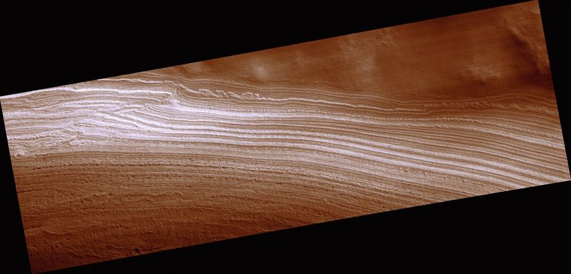 Fault in the South Polar Layered Deposits (CTX Frame - Extremely Enhanced Natural Colors; credits for the additional process. and color.: Dr Paolo C. Fienga - Lunexit Team)
This image spans a section of the south polar layered deposits (SPLD). The SPLD are composed of layers of water ice mixed with impurities (mostly dust). The most similar terrestrial analog to the SPLD are ice sheets, like those covering most of Greenland and Antarctica. 
Faults are created when rock (or, in this case, water ice) breaks due to some outside force and rocks (or ice) along either side of that break move in opposite directions. One of the most famous faults on Earth is the San Andreas Fault in California. There is a crack between the floor of the Pacific Ocean, plus a little bit of the California and Mexico coastline, and the rest of North America; the Pacific Ocean floor is moving northward along that crack, but North America is moving southward. Because the two sides are grinding against each other, they sometime stick together and then move again in jerky fashion, much like the way if you try to rub pieces of rough sand paper together. When movement along the fault occurs after a period of sticking together, this creates an earthquake.

For the case of this fault on Mars, it is unlikely that a "Marsquake" occurred when movement happened along this fault, because it is so small (over 1000 times shorter than the San Andreas Fault). This is interesting because faults are rare in the Martian polar layered deposits. The fault may have been created during widespread flow of the SPLD. Some of the stiffer ice could not flow and broke instead. Ice can only flow fast enough to create faults when it is relatively warm. Similarly, if you cool molasses enough, it becomes hard and doesn't flow. But the temperatures on Mars today are probably not warm enough to allow the creation of faults. This is why faults are so rare in the Martian ice. When were temperatures warm enough? This is still a mystery. 

Parole chiave: Mars from orbit - South Polar Layered Deposits