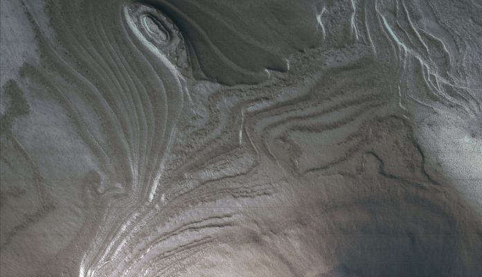 South Polar Layered Deposits (SPLD; extra-detail mgnf - MULTISPECTRUM; credits: Lunexit)
The exposure of South Polar Layered Deposits shown here also appears to be partly covered by additional debris. 
The layers appear to have been offset by a fault near the upper right corner. 
The faulting and burial visible here complicates the interpretation of the climate history of Mars based on observations of layering.
Parole chiave: Mars from orbit - South Polar Layered Deposits