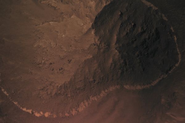 The Floor of Noctis Labyrinthus (extra-detail mgnf - MULTISPECTRUM; credits: Lunexit)
The most striking feature of many of these knobs is a thin, bright band which often wraps around the edges near the bottom, as in this extra-detail mgnf. This image was acquired in order to investigate whether this is an exposed layer of rock or the shoreline of a former body of water.
HiRISE resolves details of the bright band that indicate that this is an unusual layer of rock, rather than an old shoreline. In several places, the band is broken up along cracks, sometimes forming boulders. This indicates that the band is solid rock, while material left on a shoreline should be loose sediments. It is now exposed as rings and arcs where erosion has cut deeply enough to expose the layer.

This band must indicate some unusual event in the geologic history of the region when a different type of rock was deposited; it is strikingly different in color from the other rocks. Although it is not a shoreline, it could be material that was deposited on the floor of a much older lake or sea and then buried by other rock; it could also have been laid down by other sedimentary processes or as volcanic ash. 

Parole chiave: Mars from orbit - Noctis Labyrinthus Region